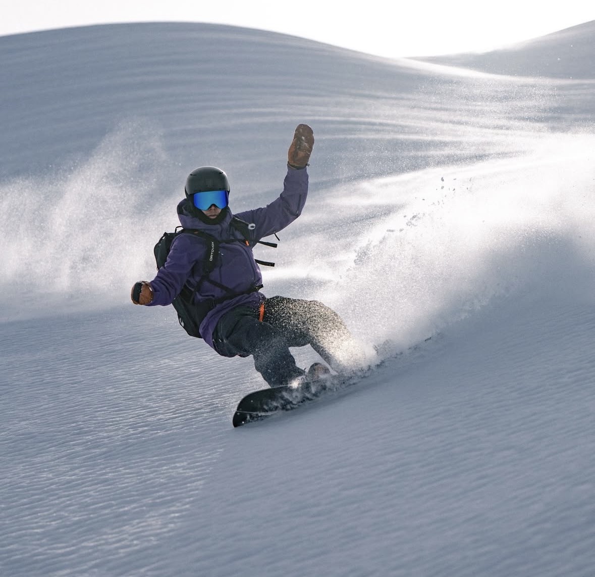 Ambassador snowboarding through backcountry powder — a real field upload.